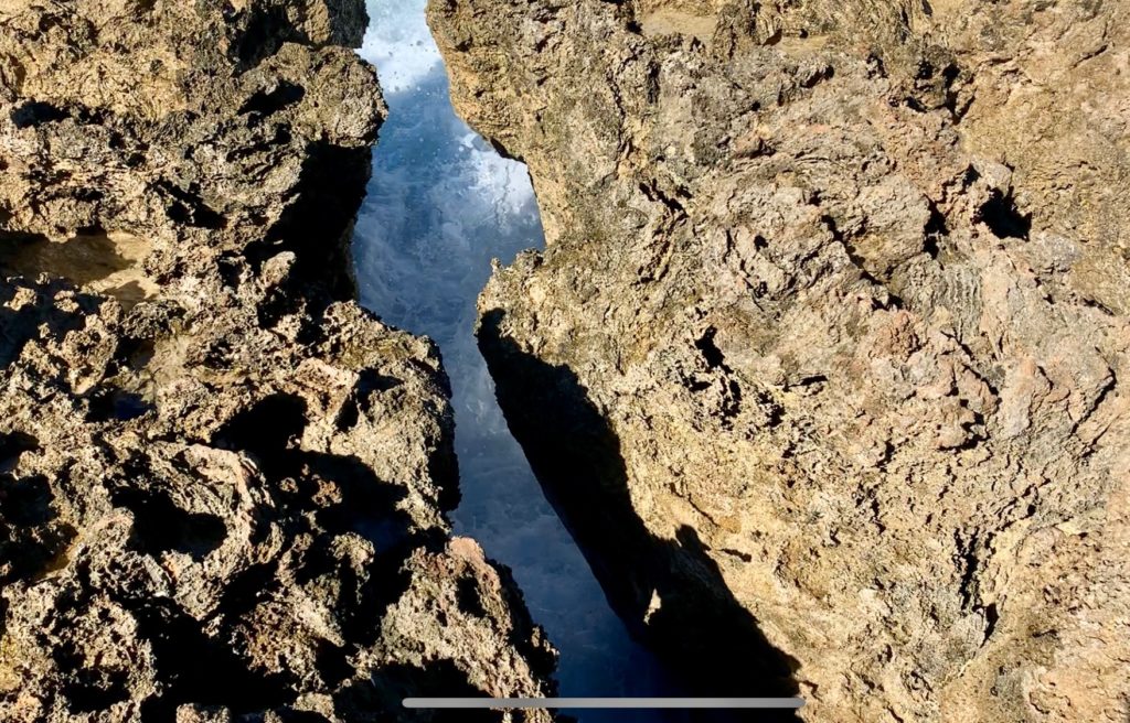 足元に穴があり、穴の底には海水が見える。