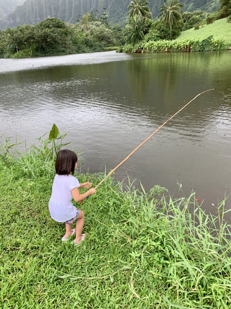 長い釣り竿を持つ娘