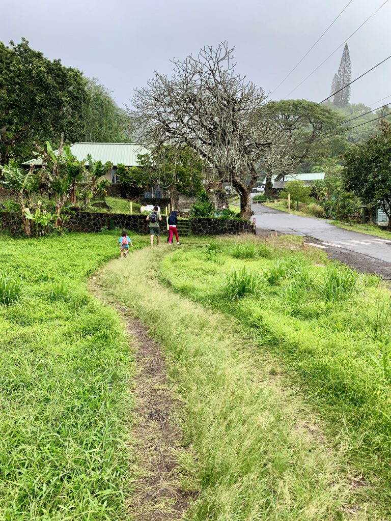 芝生の上を走る娘
空がくらく、雨が降っている